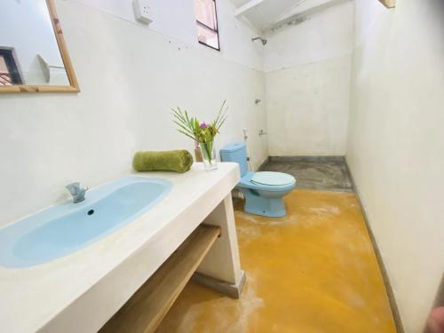 y baño con lavabo azul y aseo. en Harmony Beach Hotel, en Arugam Bay