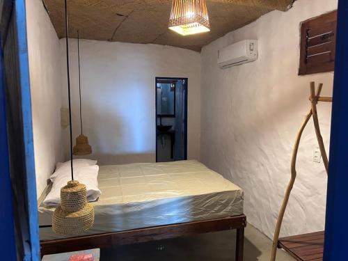 a small room with a bed in a room at Casa Aconchego da Redonda in Icapuí