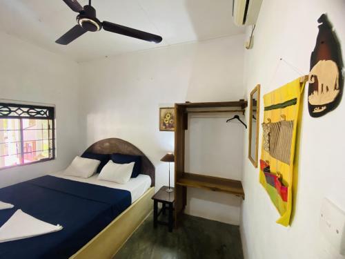 1 dormitorio con 1 cama y ventilador de techo en Harmony Beach Hotel, en Arugam Bay
