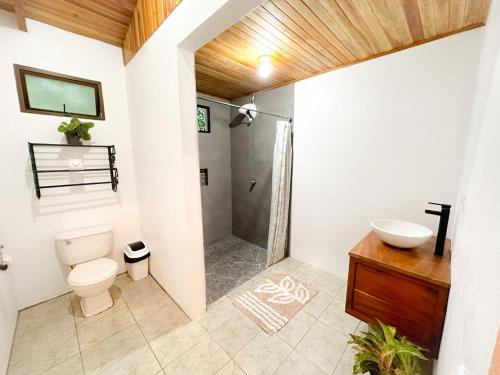 uma casa de banho com um chuveiro, um WC e um lavatório. em Edén Guest House em Monteverde