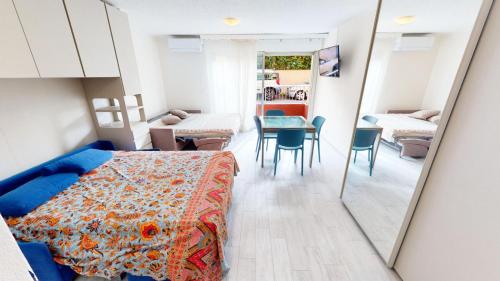 1 dormitorio con cama, mesa y espejo en Résidence Le Diplomat - Studio pour 4 Personnes 624, en Menton