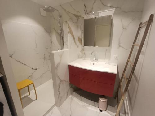 La salle de bains est pourvue d'un lavabo rouge et d'un miroir. dans l'établissement Residence Du Temple - Coup de coeur pour ce beau logement, idéalement situé ! MAE-3114, à Aix-les-Bains