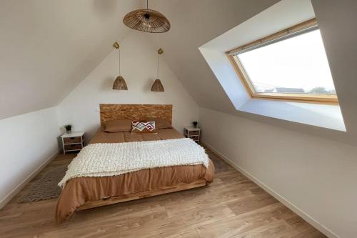 a attic bedroom with a bed and a window at Field house in Pleumeur-Bodou