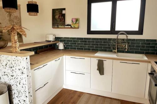 a kitchen with white cabinets and a sink at Field house in Pleumeur-Bodou