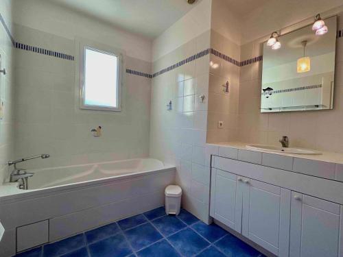 une salle de bain blanche avec une baignoire et un lavabo dans l'établissement Maison Oléron avec piscine privée, 6 couchages, proche centre et parc aquatique - FR-1-246A-158, à Dolus-d'Oléron