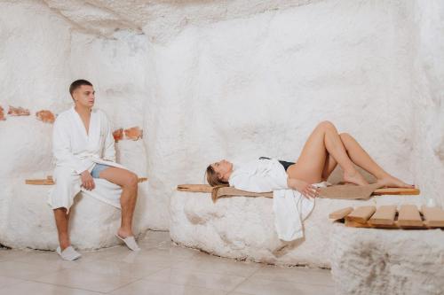 a man and a woman laying on beds at Mamababa FREE SPA & Wellness Kopaonik in Kopaonik