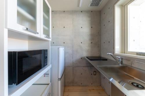 La cuisine est équipée d'un évier et d'un réfrigérateur. dans l'établissement DAIFUJI KAN - Vacation STAY 16003, à Osaka