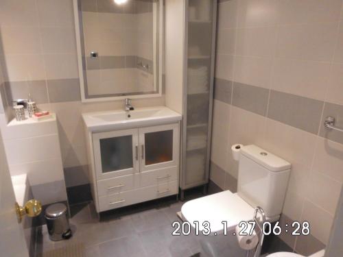 uma casa de banho com um WC, um lavatório e um espelho. em NICE 1 BEDROOM APARTMENT LOS CRISTIANOS em Los Cristianos