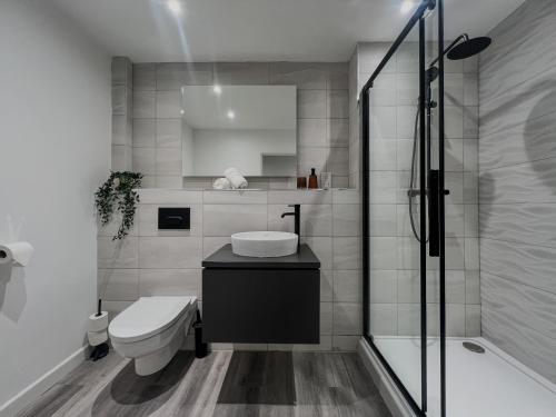 a bathroom with a toilet and a sink and a shower at Orange Rentals-City Centre - High Spec - The Aqua Suite, Sleeps 4 in Liverpool