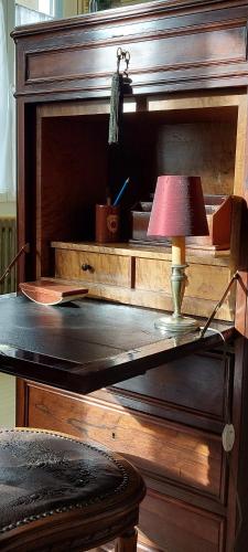 uma mesa com um candeeiro em cima de uma secretária em La Guériniere em Châteauneuf-sur-Charente