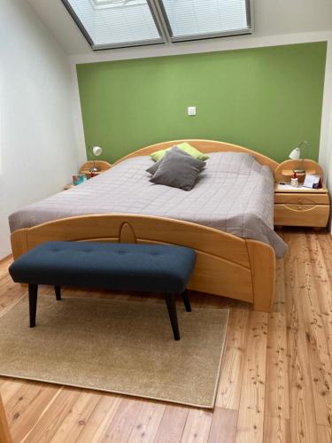 1 dormitorio con 1 cama grande con reposapiés azul en Ferienwohnung Alte Feuerwehr en Feistritz ob Bleiburg