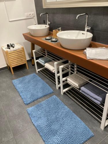 a bathroom with a sink and two blue rugs at Ferienwohnung Alte Feuerwehr in Feistritz ob Bleiburg