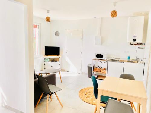 un salon blanc avec une table et des chaises dans l'établissement L'Escale l'Escapade Intervalle, à Saint-Aignan