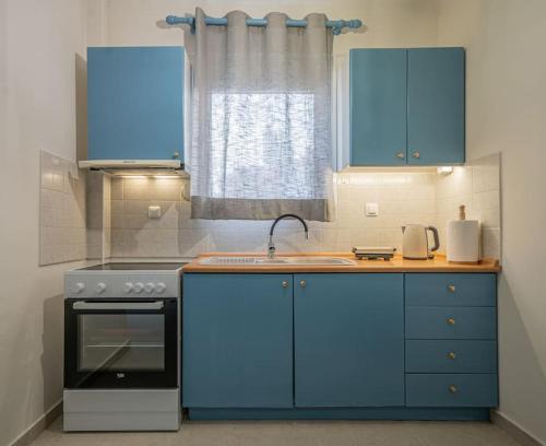 una cocina con armarios azules y fregadero en Frida's Home for 2 in Kozani, en Kozani
