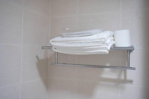 einen Handtuchhalter mit Handtüchern im Bad in der Unterkunft Home w/ City View - Pool + Fast Wifi 3016 in Manila