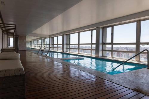 a large swimming pool in a building with windows at Quartier II by depptö in Buenos Aires