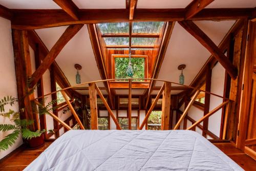 um quarto com uma cama e uma grande janela em Tukulolo Treehouses em Makaunga