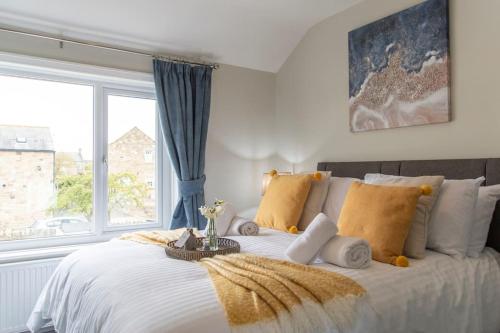 a bedroom with a large bed with a window at Snowdrop Cottage in Seahouses