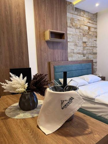 a bedroom with a bed and a wooden table at Mamababa FREE SPA & Wellness Kopaonik in Kopaonik