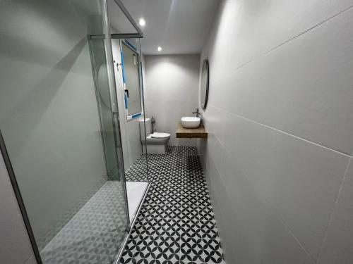een badkamer met een toilet en een glazen douche bij Oktheway Riego de Agua 23 in A Coruña
