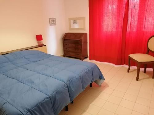 a bedroom with a blue bed and a red curtain at Eva 's flat with large sunny balcony and lagoon view in Venice-Lido