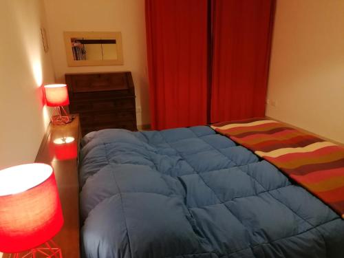 a bedroom with a blue bed and a red curtain at Eva 's flat with large sunny balcony and lagoon view in Venice-Lido