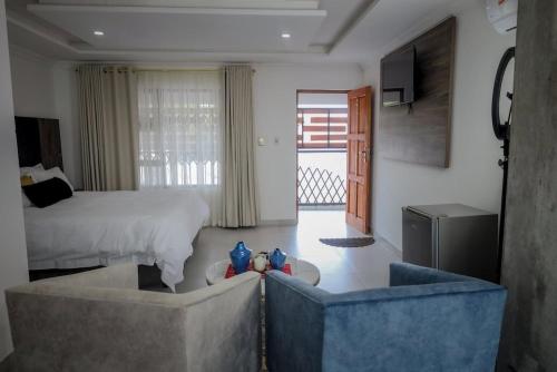 Hotel El Infinito في كيمبتون بارك: غرفة نوم مع سرير وغرفة معيشة مع أريكة
