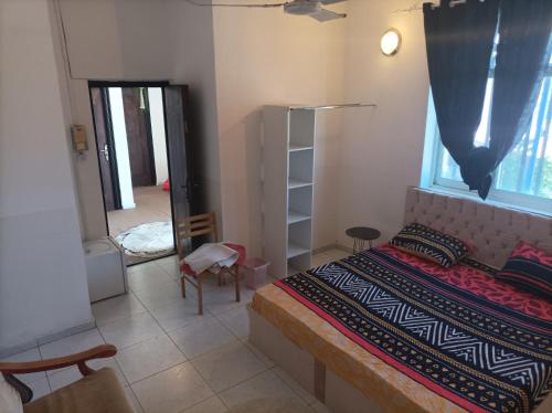 a bedroom with a bed and a window and a chair at Brise de Mer Azur in Djibouti