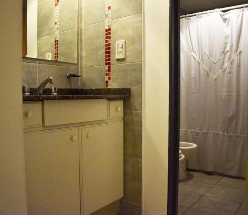 y baño con lavabo, aseo y espejo. en Departamento Amoblado Nva Cba en Córdoba