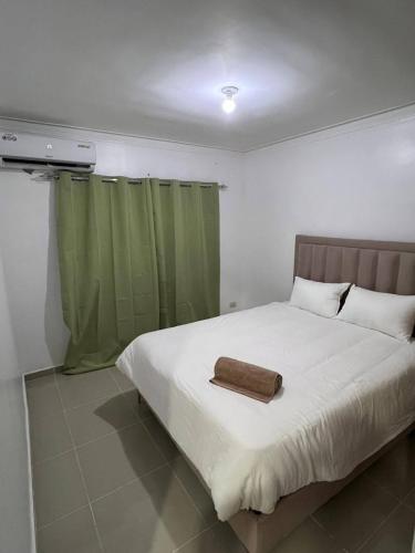 Un dormitorio con una cama con una toalla. en Flor de lirio, en Juan López