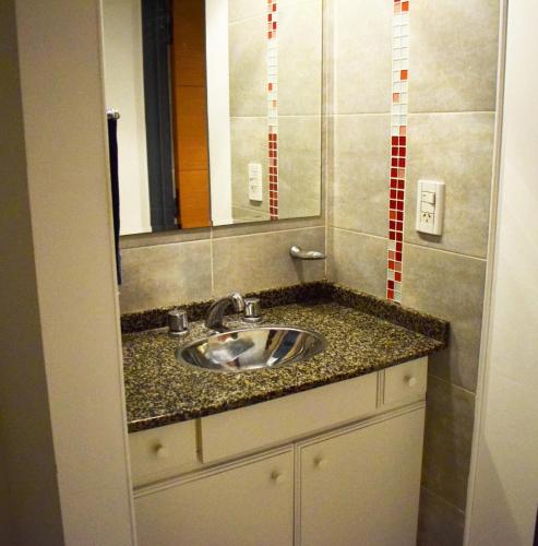 y baño con lavabo y espejo. en Departamento Amoblado Nva Cba en Córdoba