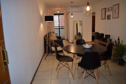 comedor y sala de estar con mesa y sillas en Departamento Amoblado Nva Cba en Córdoba