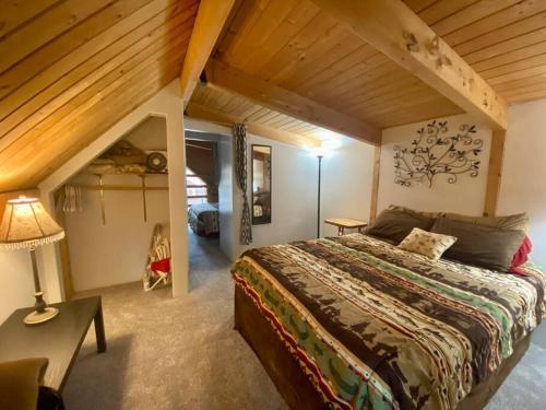 - une chambre avec un grand lit et un plafond en bois dans l'établissement Talkeetna Log Cabin with Hot Tub Unit 1, à Talkeetna