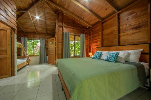 a bedroom with a bed in a room with wooden walls at Eden Organic Farm & Bungalows in Fortuna