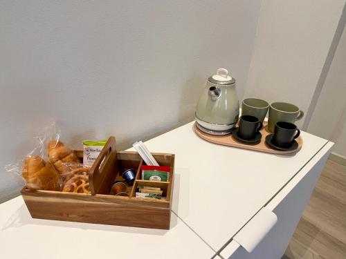 eine Schachtel Gebäck und Kaffeetassen auf einer Theke in der Unterkunft 7Suites in Empoli