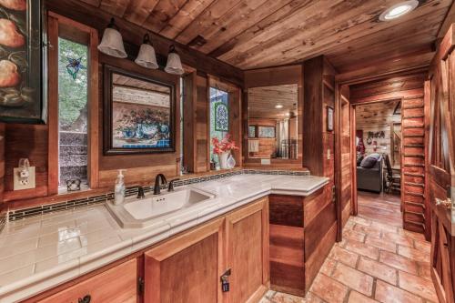 a kitchen with a large sink and wooden walls at Two Bedroom Cabin Used To Belong to Deborah Winger! in Ruidoso