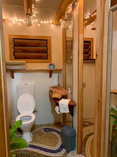 a bathroom with a toilet in a tiny house at Tukulolo Treehouses in Makaunga