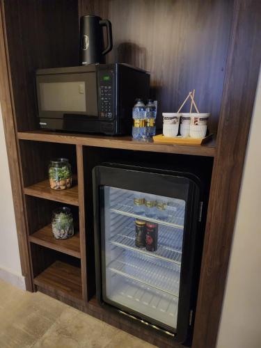 a microwave and a refrigerator in a kitchen at Eliana Hotel in Al Khobar