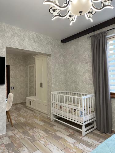 a baby room with a crib and a chandelier at Sinay Hotel & Restaurant in Chechel'nyk