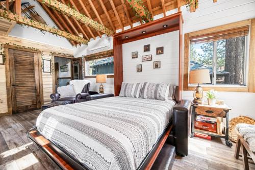 um quarto com uma cama, uma cadeira e uma janela em Hansel and Gretel Cottage em Big Bear City