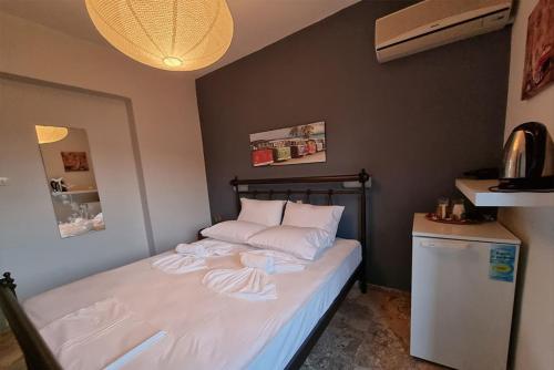 a small bedroom with a bed and a refrigerator at Irene Vìlla in Poros