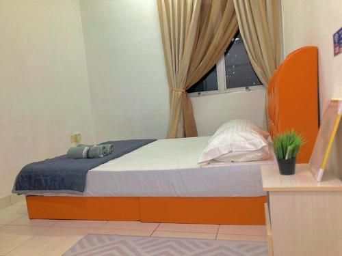 a bedroom with a bed with an orange headboard and a window at NR CYBER ROOMSTAY 2-Shared Apartment in Cyberjaya