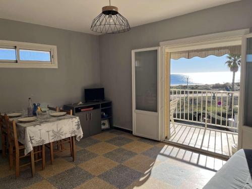 d'un salon avec une table et une porte coulissante en verre. dans l'établissement Appartement à 2 pas de la plage avec terrasse et parking - FR-1-387-186, à Marseillan
