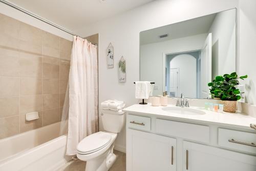 een witte badkamer met een toilet en een wastafel bij Maria Condo with Community Pool Access in Harker