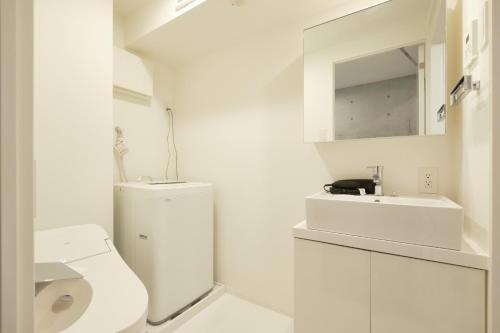 biała łazienka z toaletą i umywalką w obiekcie Toyocho SA-KU-RA - Vacation STAY 45258v w Tokio