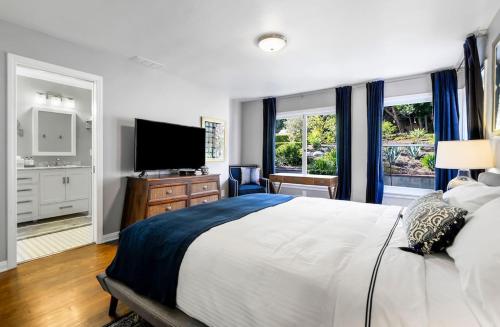 1 dormitorio con 1 cama grande y TV de pantalla plana en HAMPTON HOUSE PACIFIC PALISADES CA Ocean View Family & Pet Friendly Weekly & Monthly Discounts, en Los Ángeles