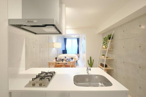 cocina blanca con fregadero y fogones en Toyocho SA-KU-RA - Vacation STAY 44020v, en Tokio