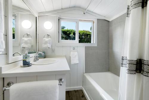 Baño blanco con bañera, lavabo y espejo en HAMPTON HOUSE PACIFIC PALISADES CA Ocean View Family & Pet Friendly Weekly & Monthly Discounts, en Los Ángeles