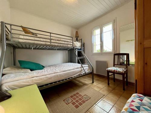 een slaapkamer met 2 stapelbedden en een stoel bij Maison La Brée-les-Bains, 3 pièces, 5 personnes - FR-1-246A-181 in La Brée-les-Bains
