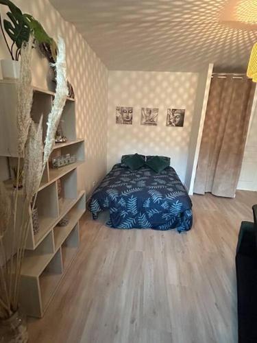 a bedroom with a bed and a book shelf at Appart cosy proche le havre in Harfleur